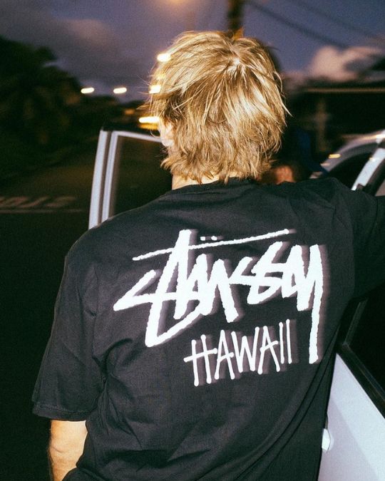 surfista con camiseta logotipo stussy