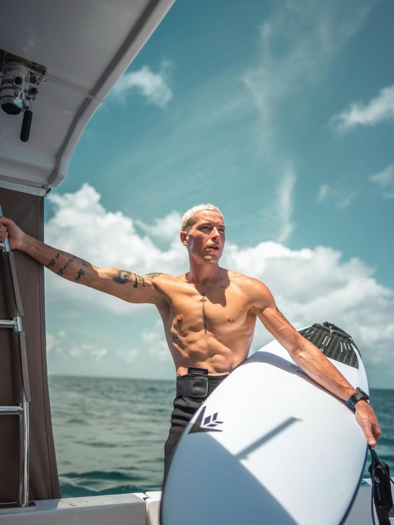 Taz Skylar actor español de One Piece con tabla de surf Firewire